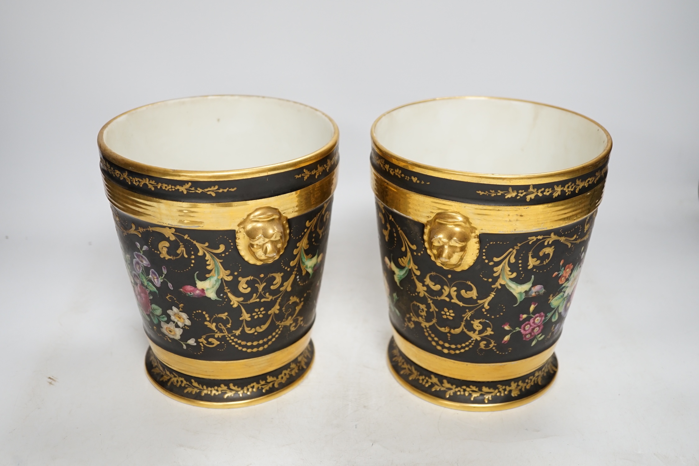 A pair of Paris porcelain cache pots and under dishes, black ground, floral and gilt decoration, 18.5cm high. Condition - both have wear to gilding and black ground, one pot has a star crack to base
